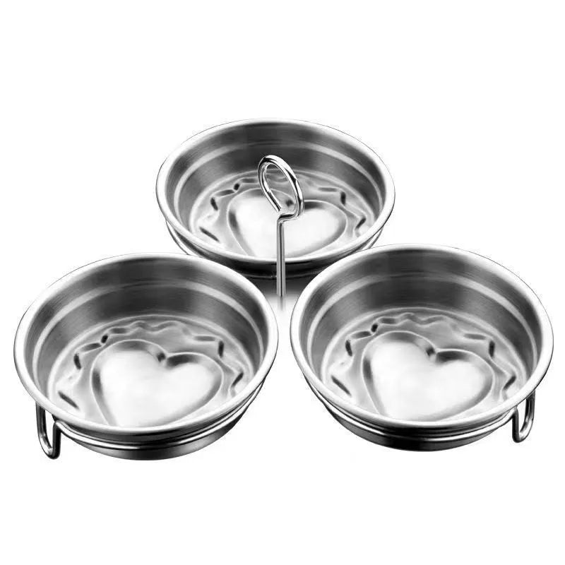 Stainless steel heart-shaped egg steamer next to a round model on a kitchen counter.
