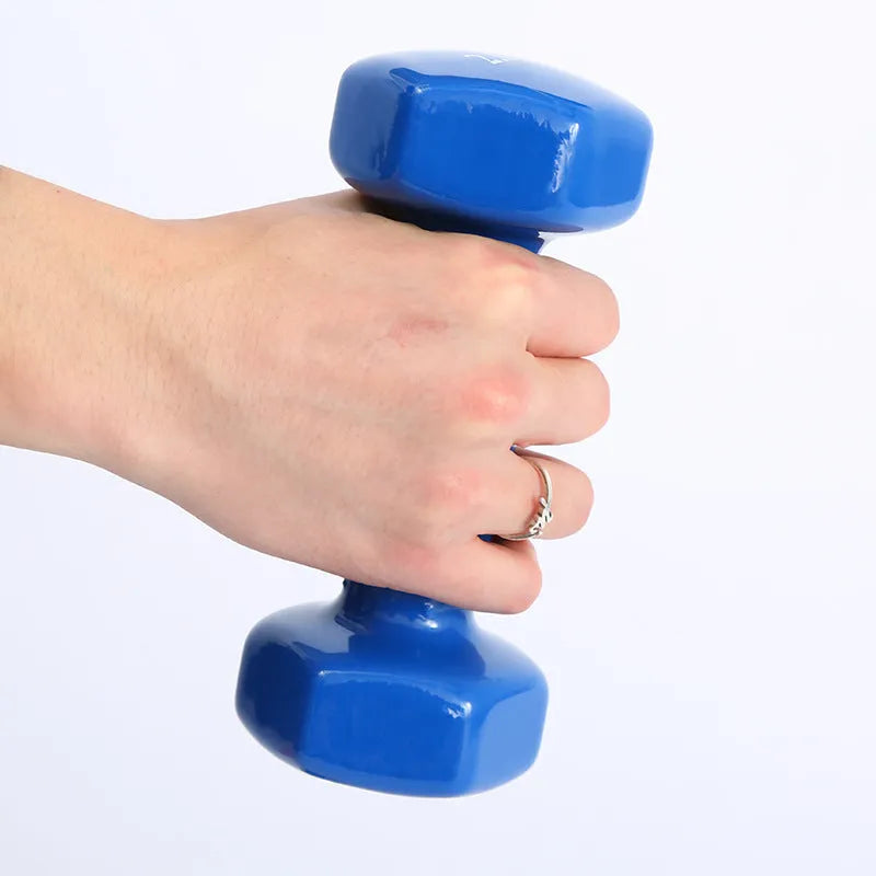 Colourful PVC-coated plastic hexagonal fitness dumbbells in bright colours on a gym floor