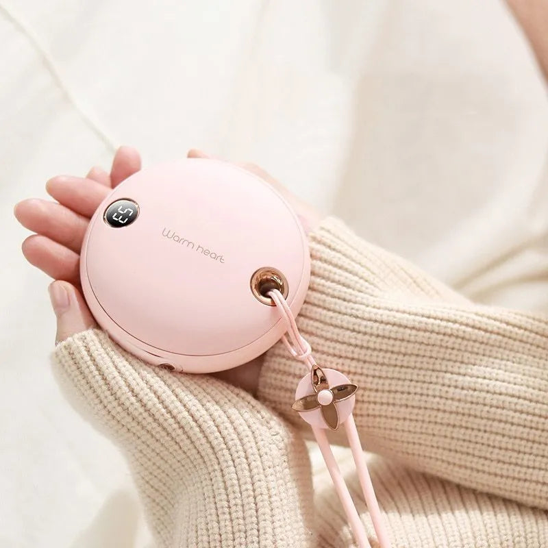 Green 5000mAh hand warmer power bank with digital display, shown next to its included USB charging cable.