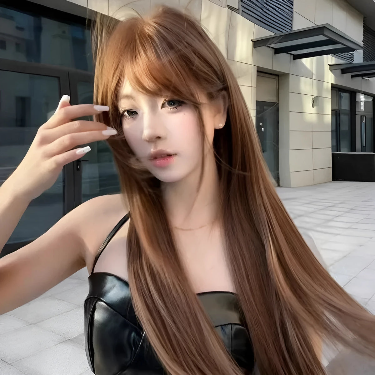 Warm brown long straight synthetic wig with fringe bangs on a model.