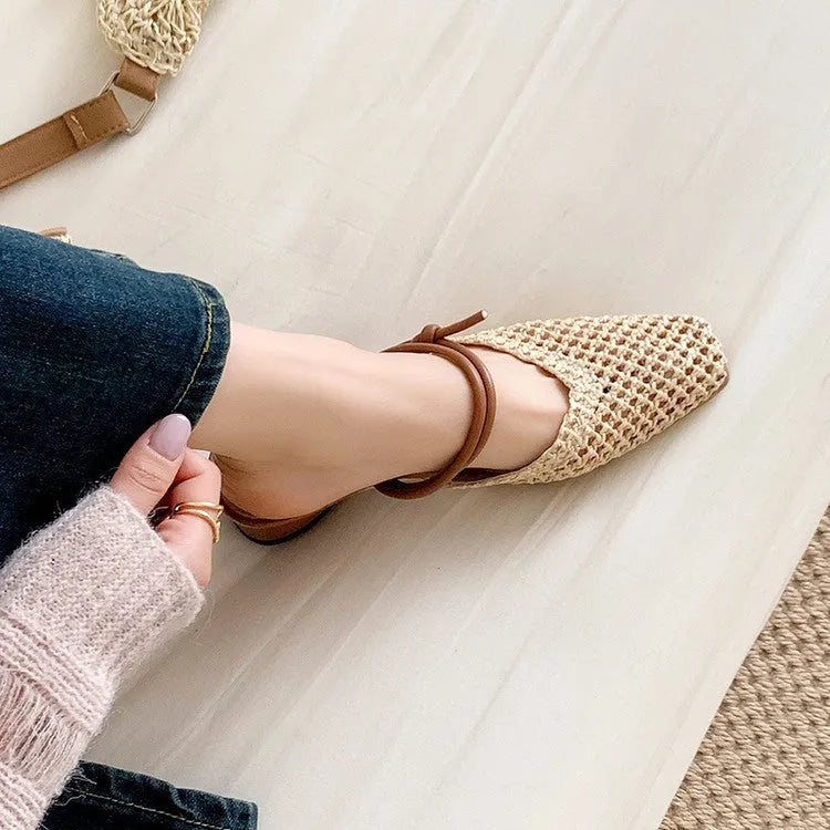 Women's black square toe slippers with hollow-out design and a chunky heel on a rubber sole.