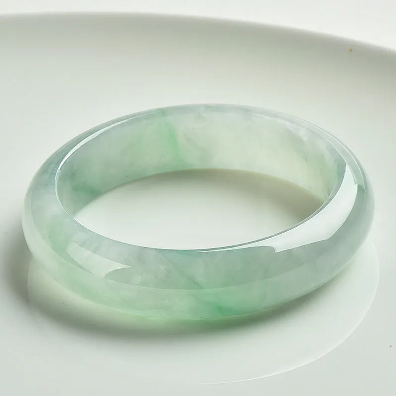 Light green jade bracelet showing natural stone colouration with size markings from 53 to 64