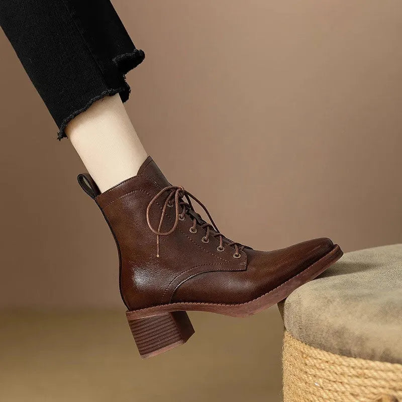 Women's black pointed-toe ankle boots with a low heel on a plain background.