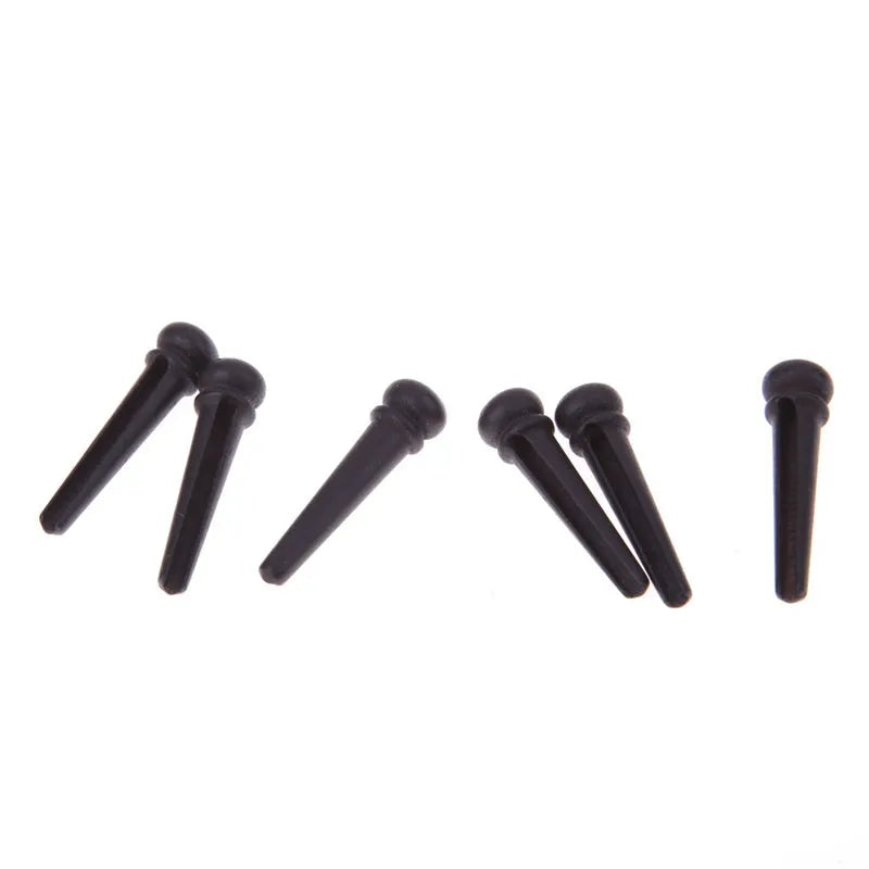 Six ebony guitar string nails with matt black finish and 5.3mm bayonet diameter