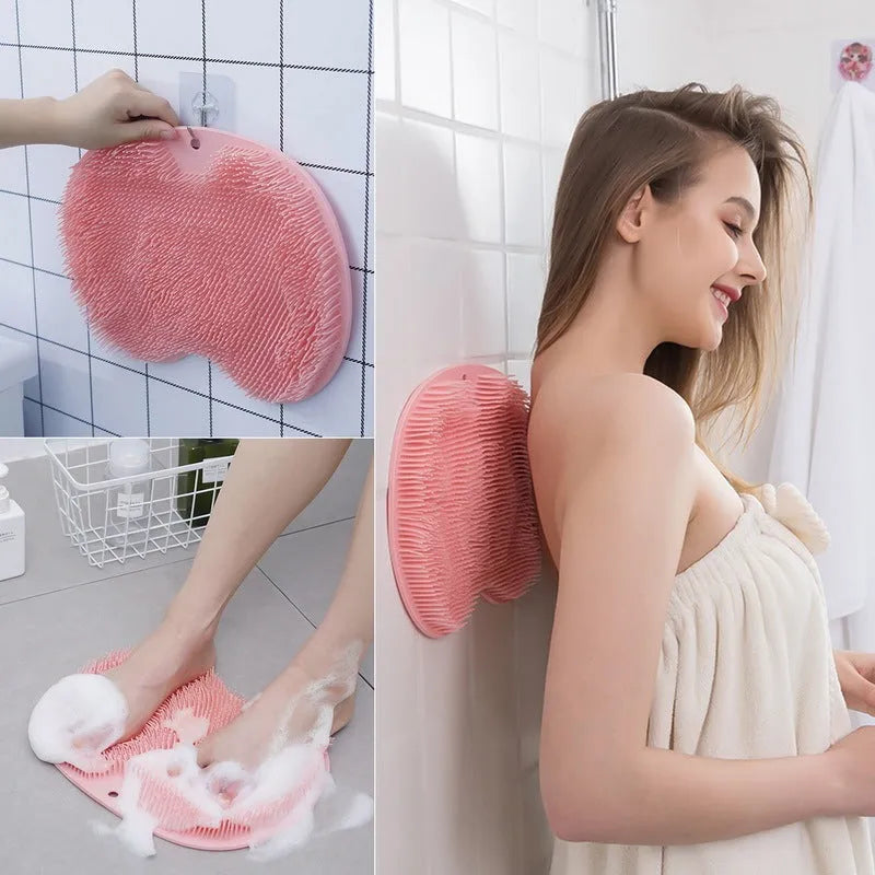 Orange silicone bristle bath brush with suction cup base on bathroom tiles.