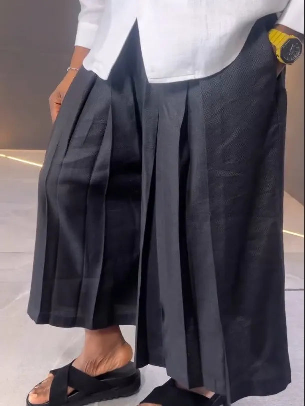 White asymmetric front long sleeve shirt and black pleated trousers co-ordinates set on a hanger