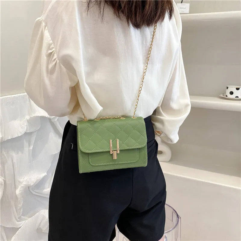 Women's diamond lattice chain crossbody bag in black with adjustable strap
