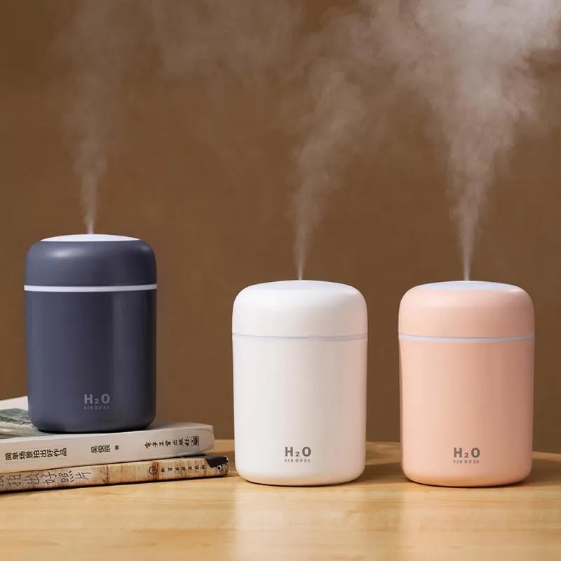 Pink, white, or navy blue USB desktop humidifier with colourful LED lights and water tank.