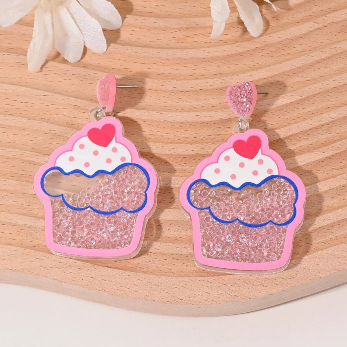 Acrylic drop earrings shaped like a strawberry, cherry, watermelon, pineapple, cake, ice cream, and coconut tree on a white background.