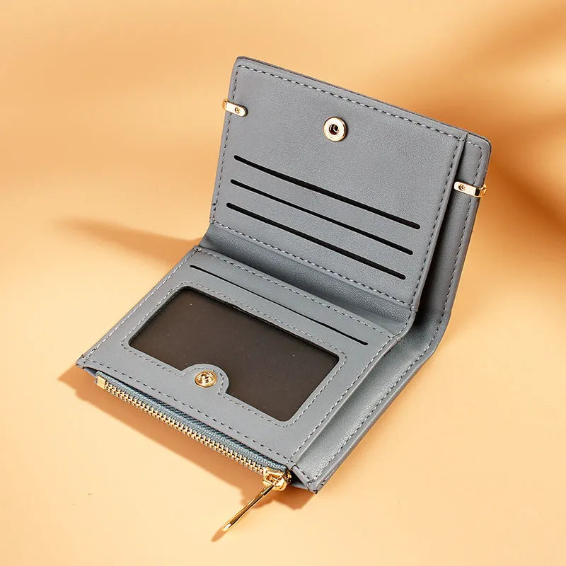 Women's black PU leather bifold wallet open to show card slots, zipper compartment, and change pocket.