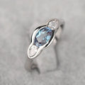 Geometric ellipse-shaped women's ring with zircon inlay in a white gold finish, shown on a hand.