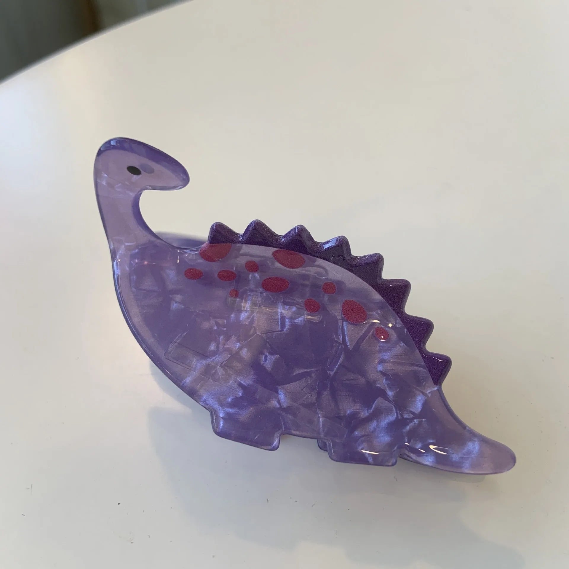 Colourful dinosaur-themed acrylic jaw hair clip showing multiple design options