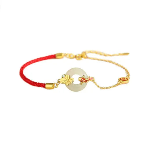 Gold and red women's bracelet with a silver peace buckle, red rope, and Hetian jade charm.