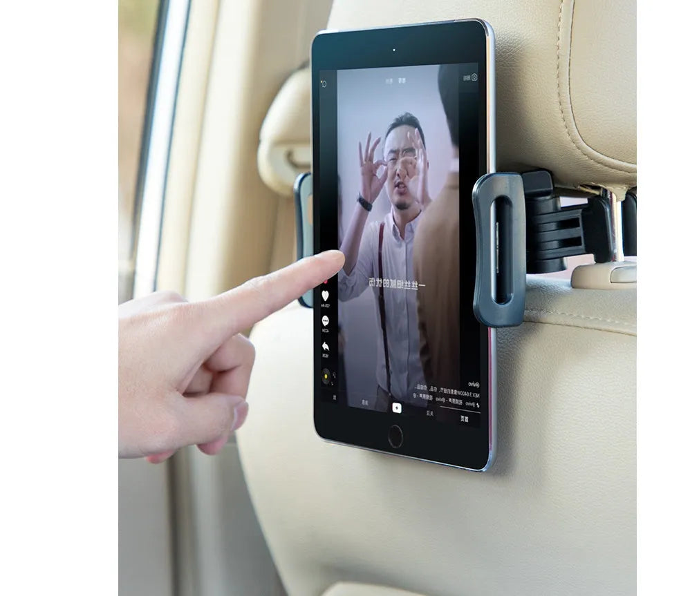 Black car phone holder mounted on vehicle rear seat base with tablet secured in adjustable grip
