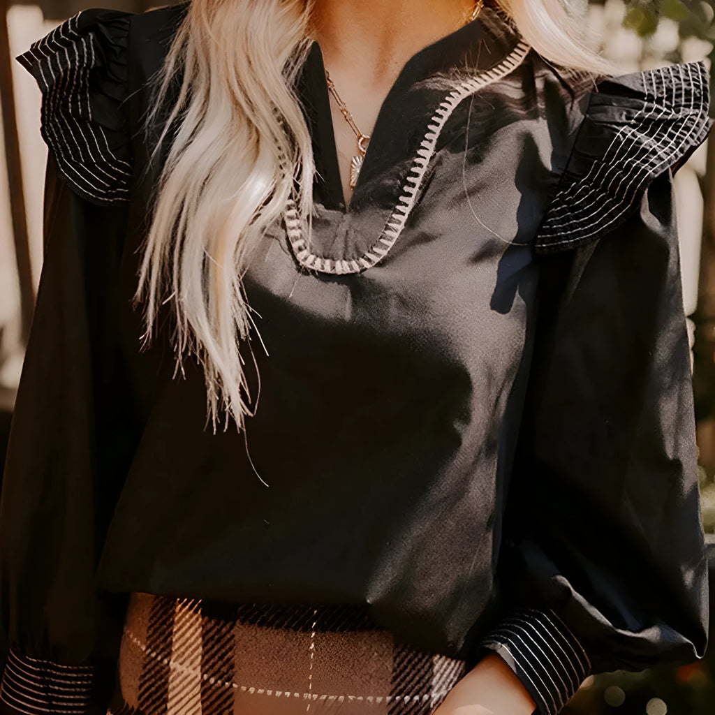Black women's V-neck blouse with long ruffle sleeves and contrast colour stitching.