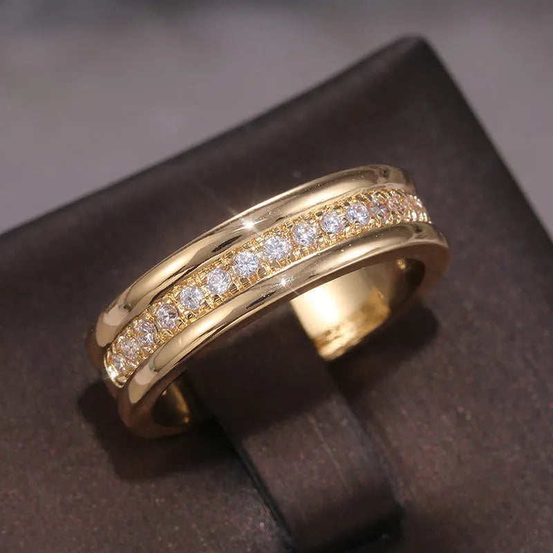 Gold plated copper geometric ring with inlaid zircon stone on white background