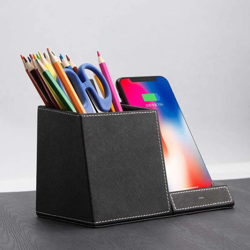 Black leather wireless charging station with pen holder slots showing phone charging on surface