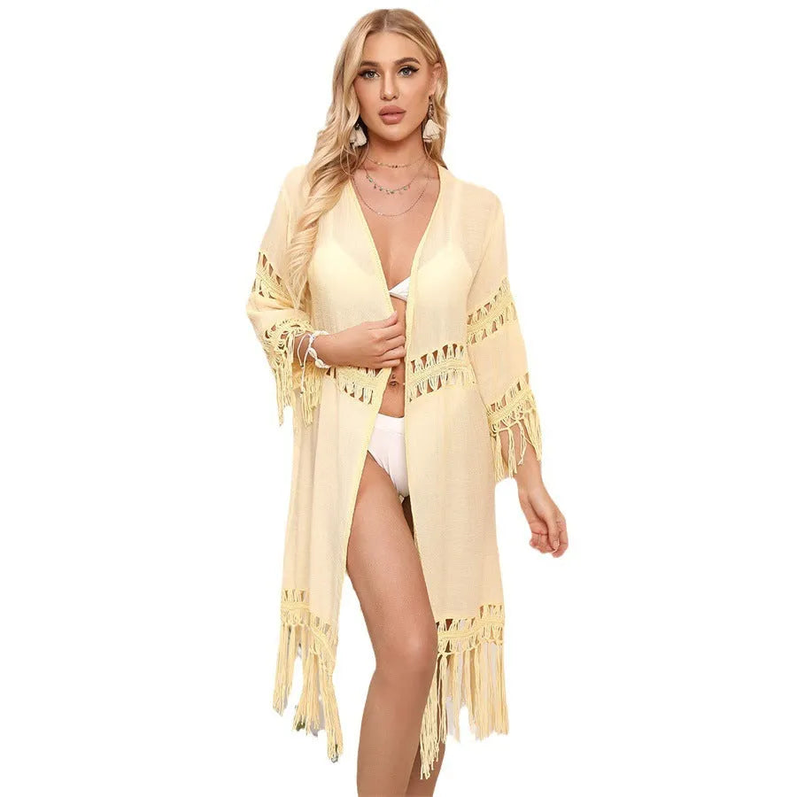 A woman's hand-crocheted acrylic beach cover-up cardigan with tassel details, shown in water green colour.