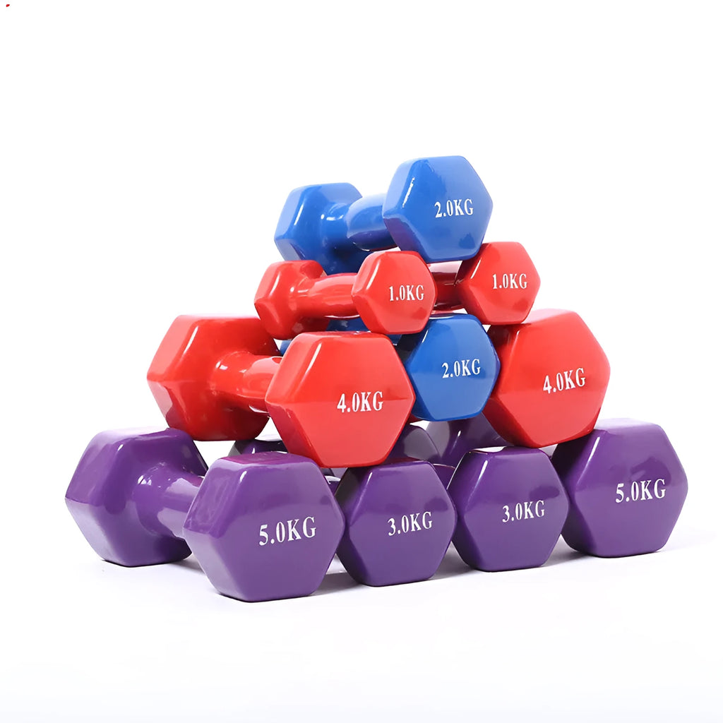 Colourful PVC-coated plastic hexagonal fitness dumbbells in bright colours on a gym floor