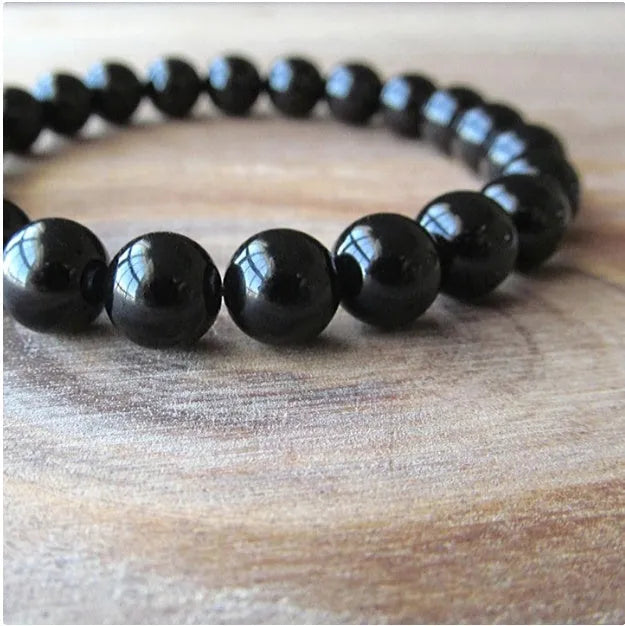 Black onyx bracelet with 8mm geometric agate beads on a black elastic cord.