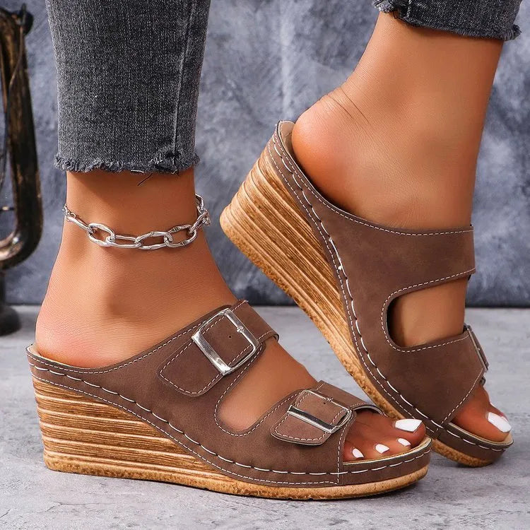 Women's beige wedge heel slippers with a decorative outer buckle fastening on a rubber sole