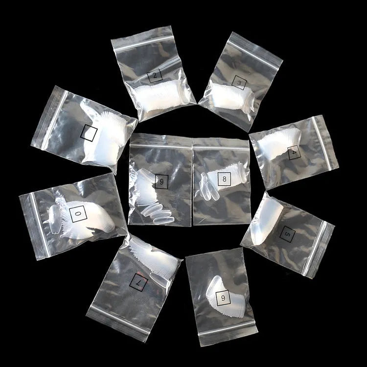 500 clear acrylic false nails in 10 sizes, made from ABS plastic, arranged on a table.