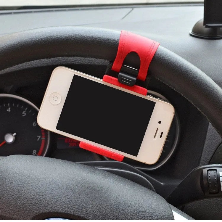 Black steering wheel phone mount holder clipped to a car wheel, holding a large smartphone.
