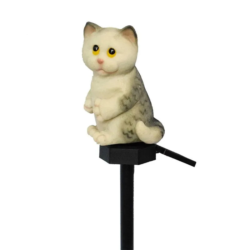 Brown resin cat-shaped solar garden light with LED on a lawn.