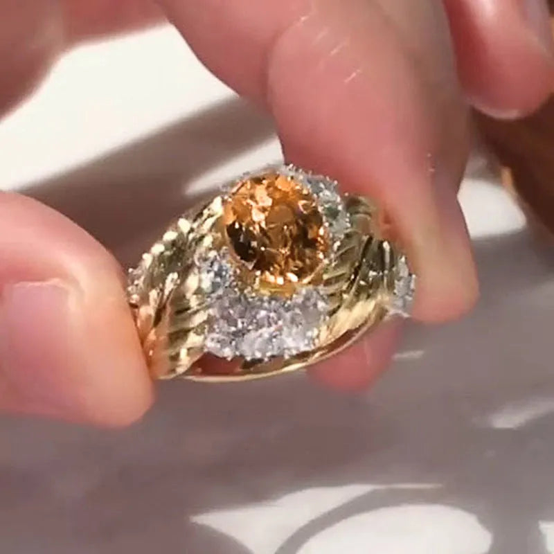 Gold-coloured women's feather ring with embossed design and yellow zircon stones on copper band