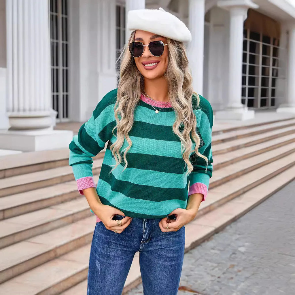 Woman wearing a loose blue and white striped acrylic sweater with long sleeves and a round neck.