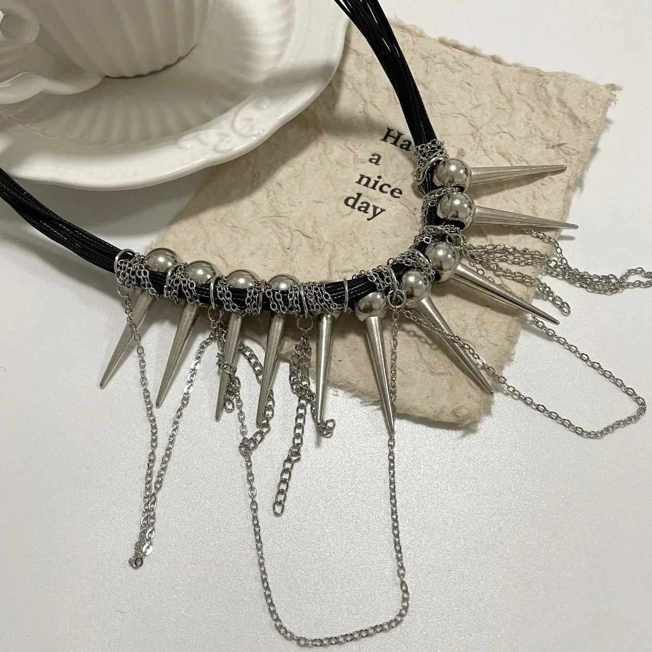 Women's leather tassel necklace with round beads and rivet detailing in electroplated finish