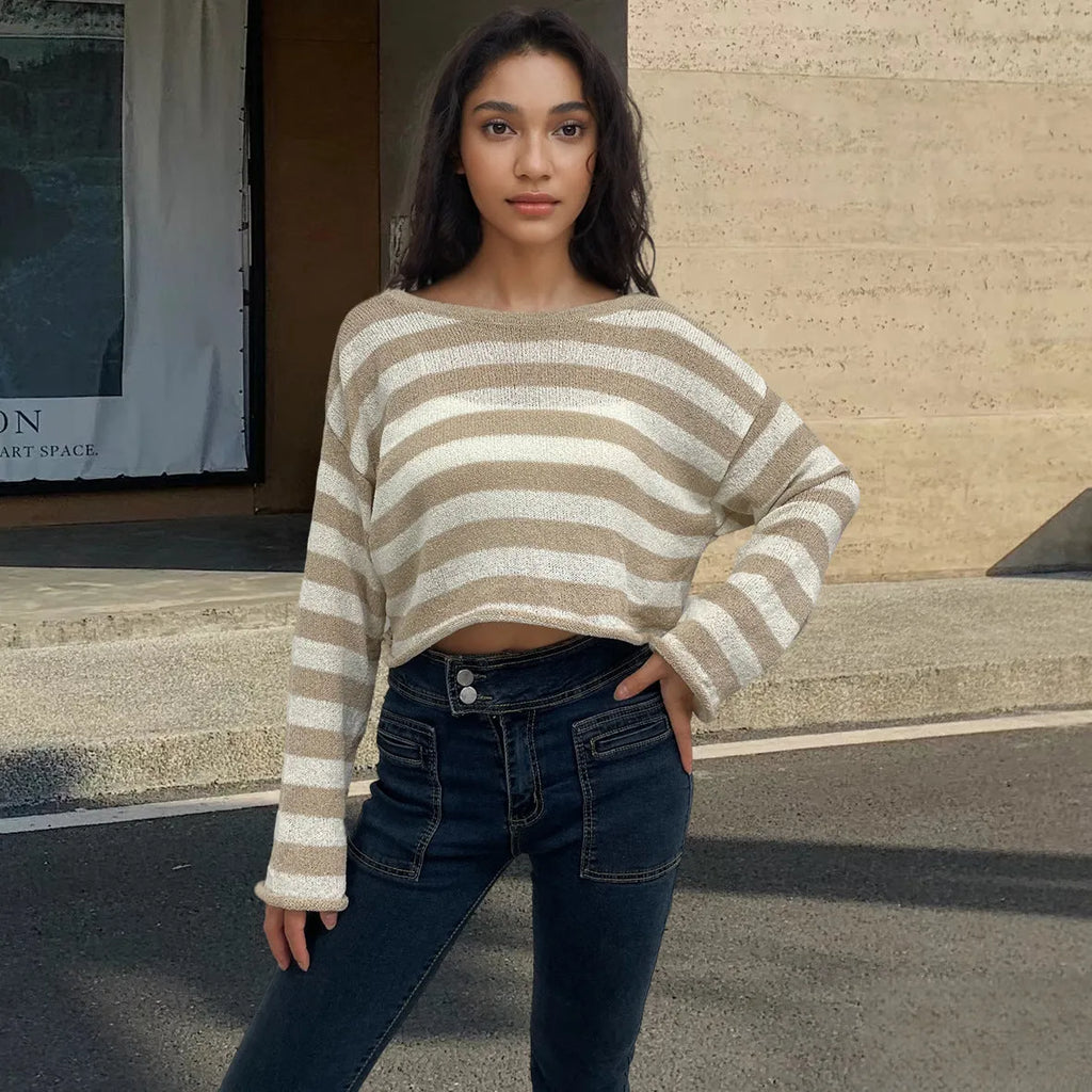 Black and white striped long-sleeved sweater worn as a pullover with an exposed navel style detail.