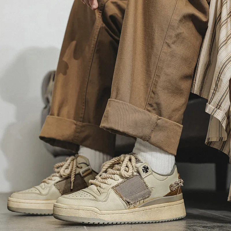 Beige low-top men's skateboard sneakers with a round toe and front lace-up on a rubber sole.