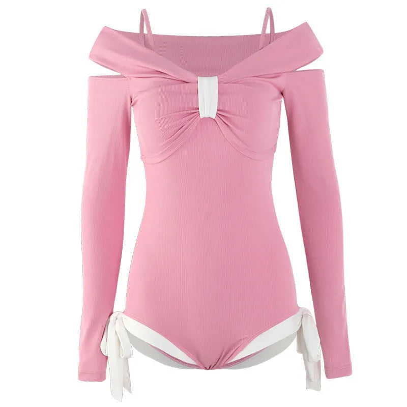 Women's pink and black long sleeve one-piece swimsuit on a hanger