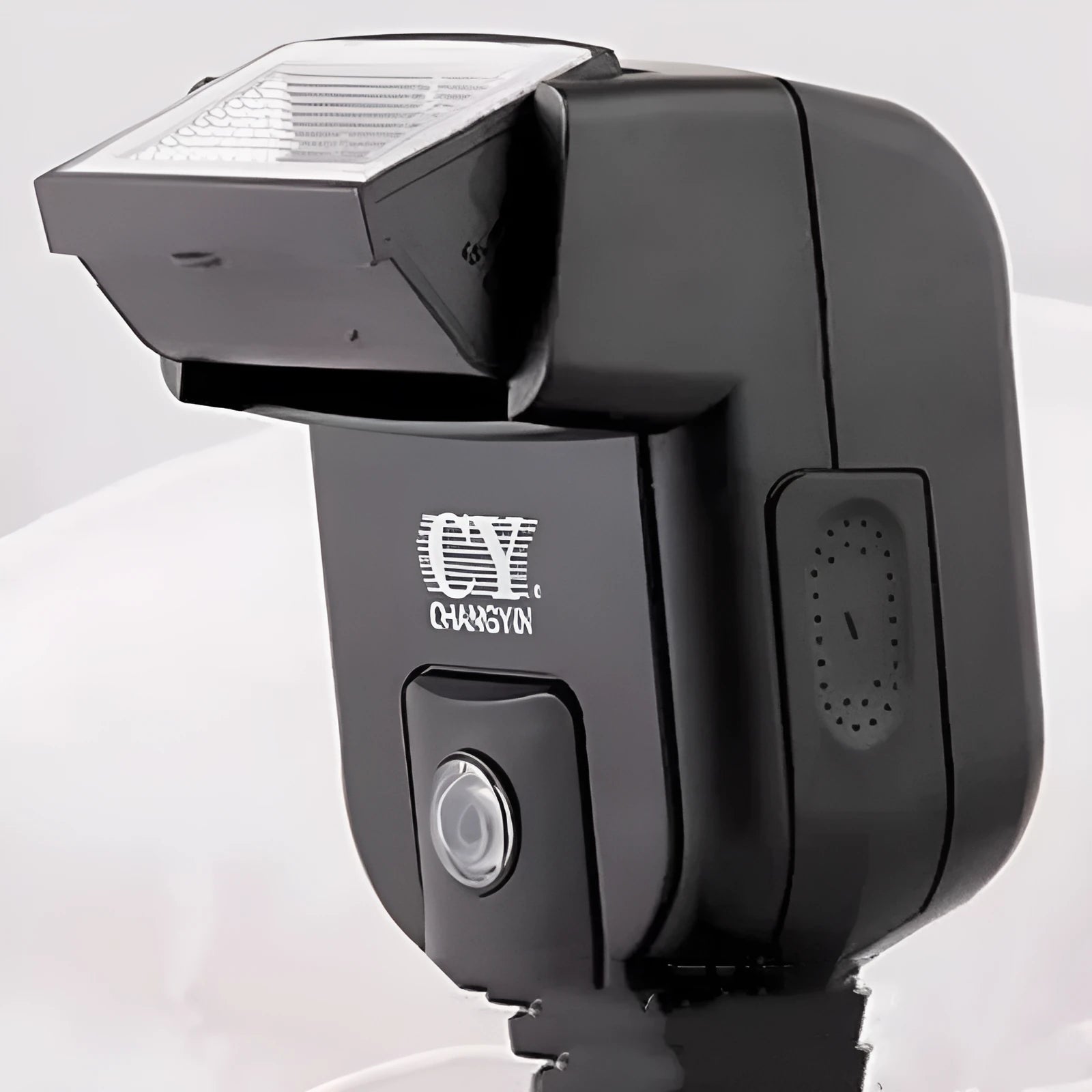 Compact black hot shoe flash unit tilted upwards on a DSLR camera