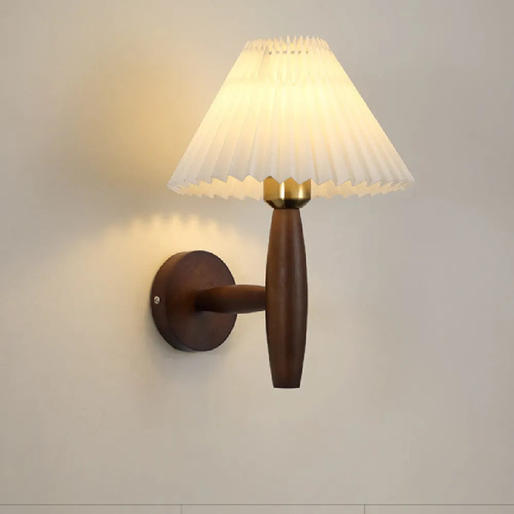 American retro-style wooden wall lamp with a fabric shade in a walnut finish on a bedroom wall.
