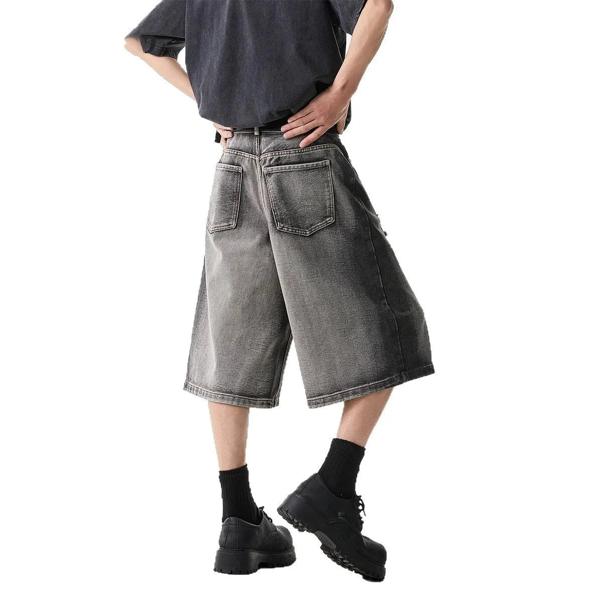 Grey loose fit denim shorts with distressed holes and a cropped length on a hanger.
