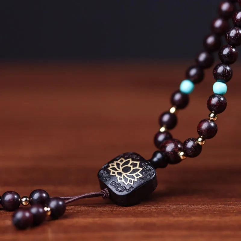 Zambia rosewood Buddha bead bracelet with flat lotus pendant, showing 108 wooden beads.