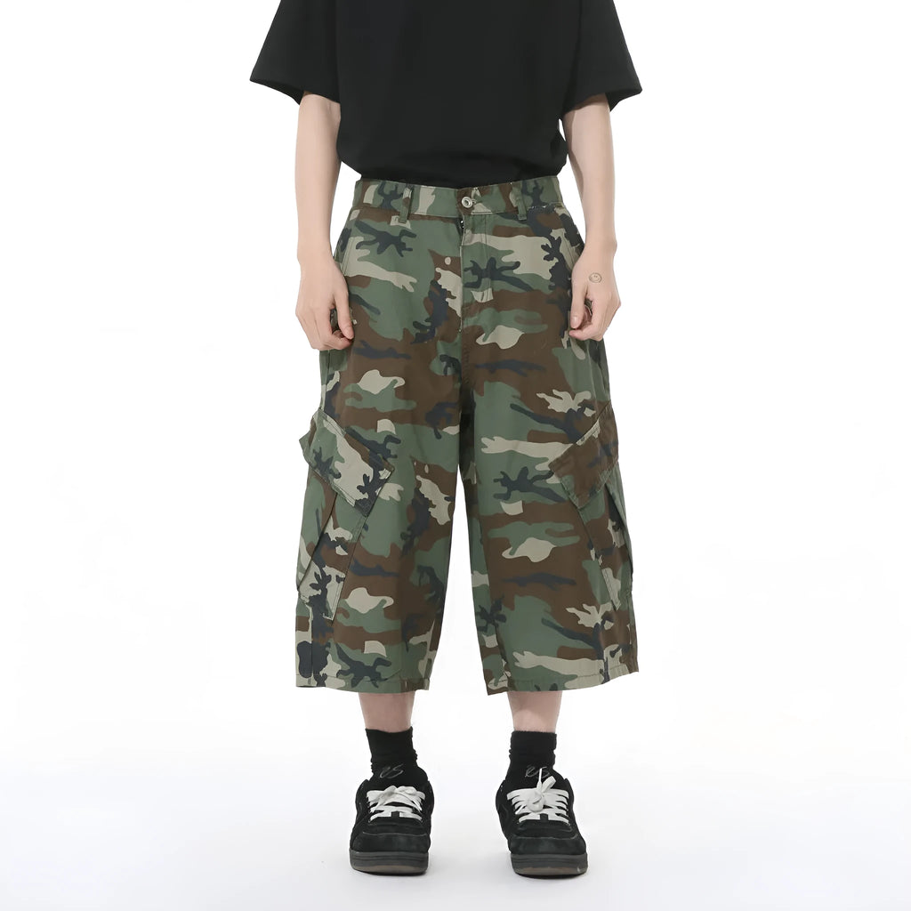 Men's camouflage-coloured cotton jeans with wide loose legs, cropped length, and side pockets on a plain background.
