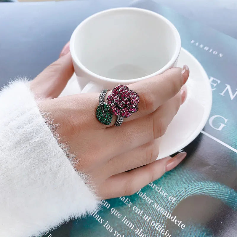 Black gold geometric flower personality ring with red corundum simulation stone on female hand