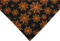 Black and orange reversible Halloween dog bandana showing pumpkin and spider web patterns with adjustable neck closure
