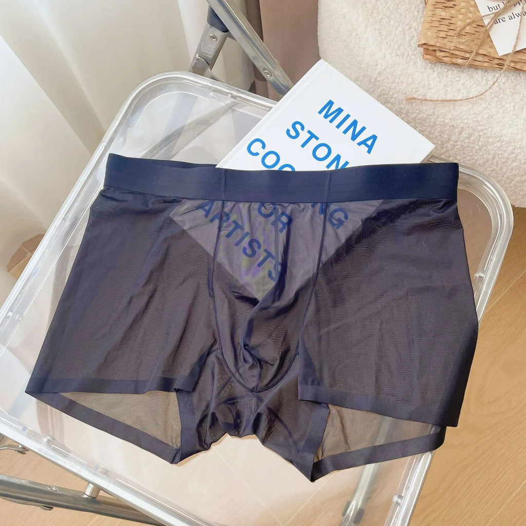 Men's thin grey seamless boxer shorts laid flat, showing knitted nylon fabric and mid-waist design.