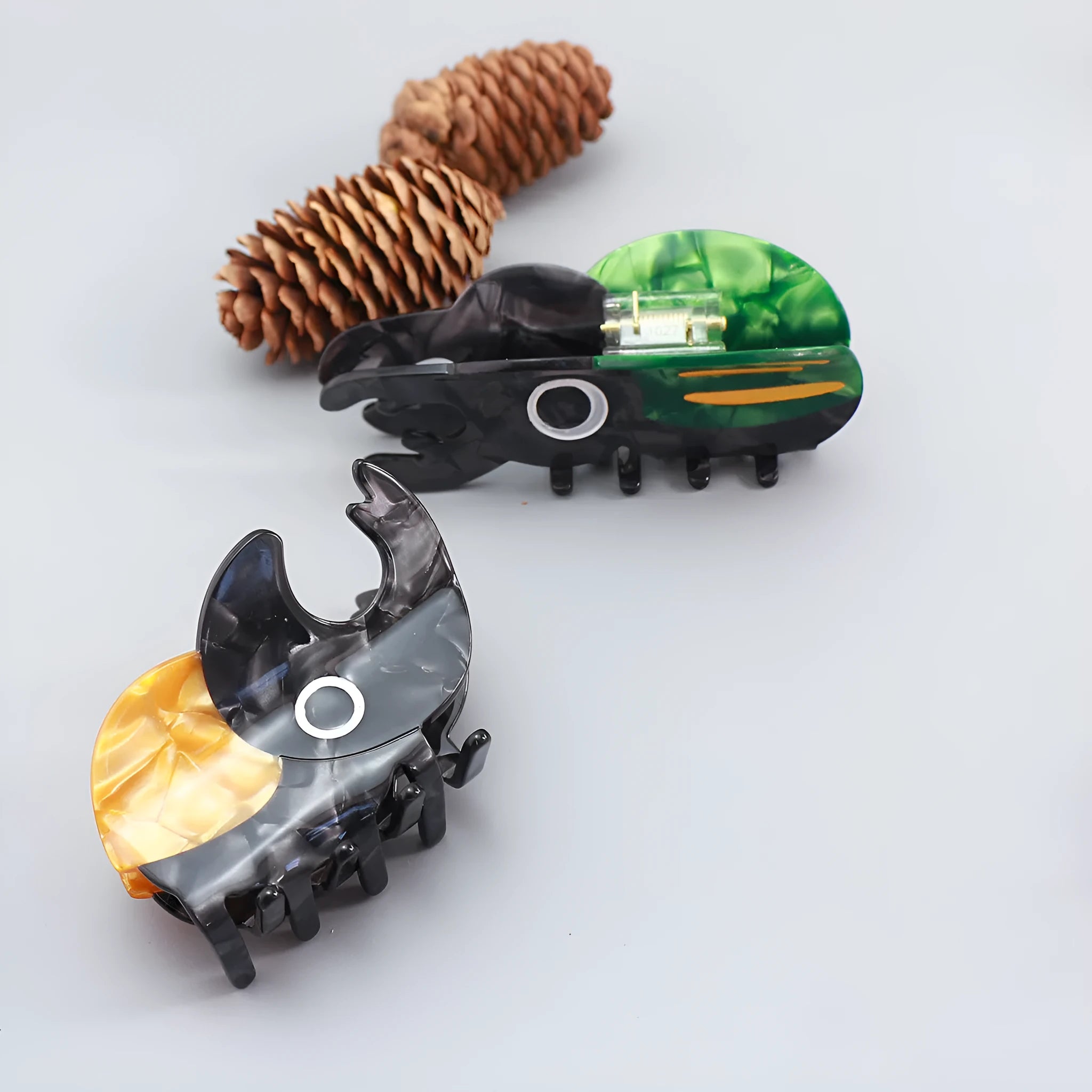 Handmade cartoon beetle grip brooch made from cellulose acetate in green, orange, or white insect designs.