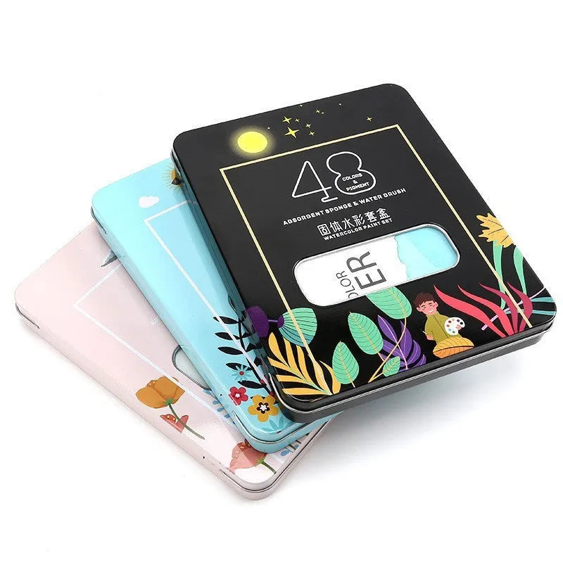 Metal tin open to show 48 pans of solid watercolour paint in various colours including black, pink, and blue.