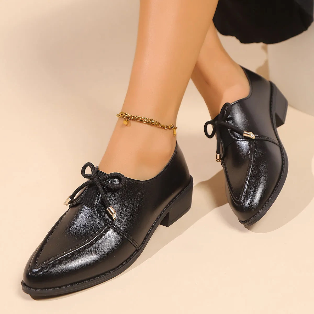 Women's brown leather-look loafers with a large bow detail on the front.