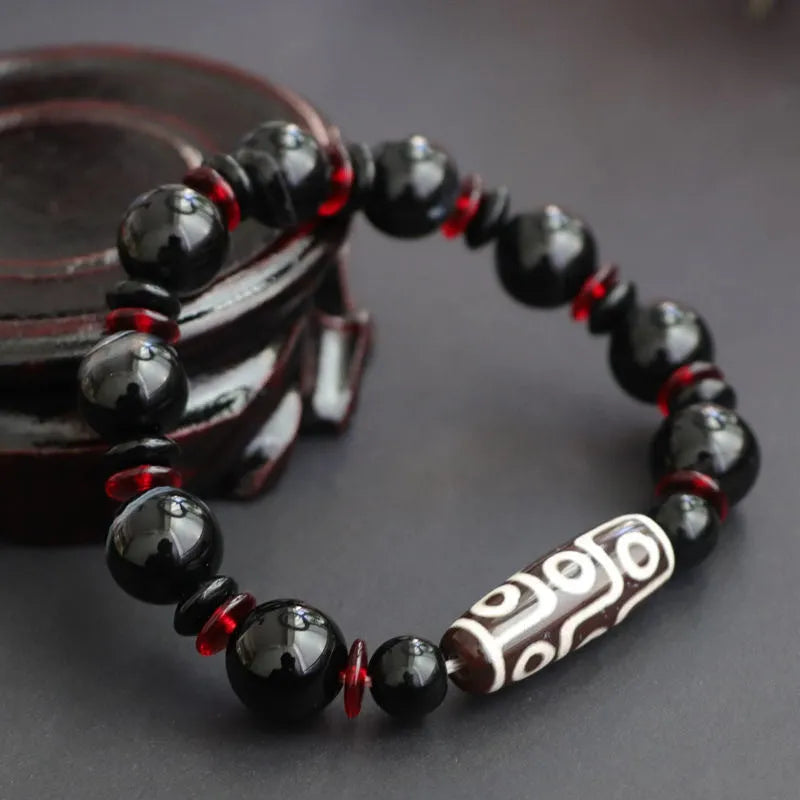 Hand-woven black agate Dzi bracelet with geometric 11mm beads on wrist
