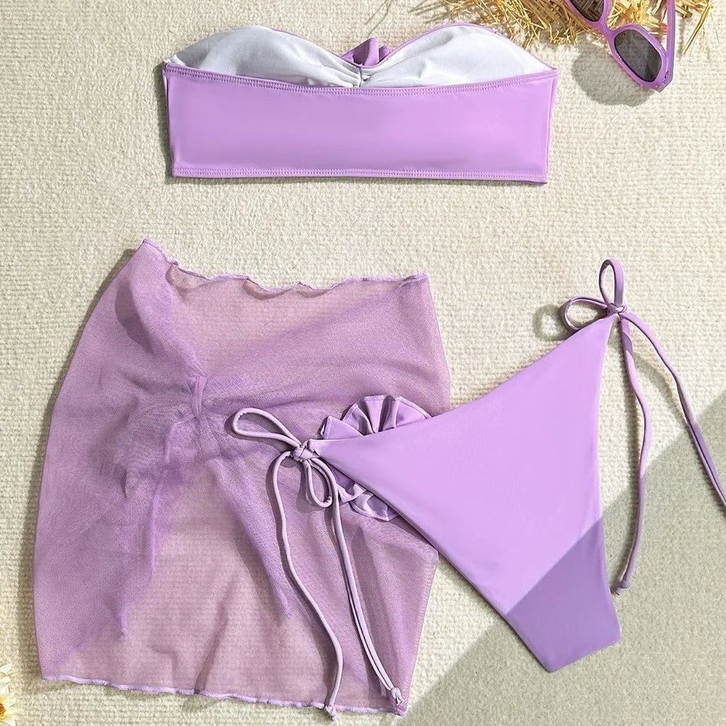 Women's pink swimsuit set with three-dimensional floral tie front tube top, high-waisted pants, and matching skirt.