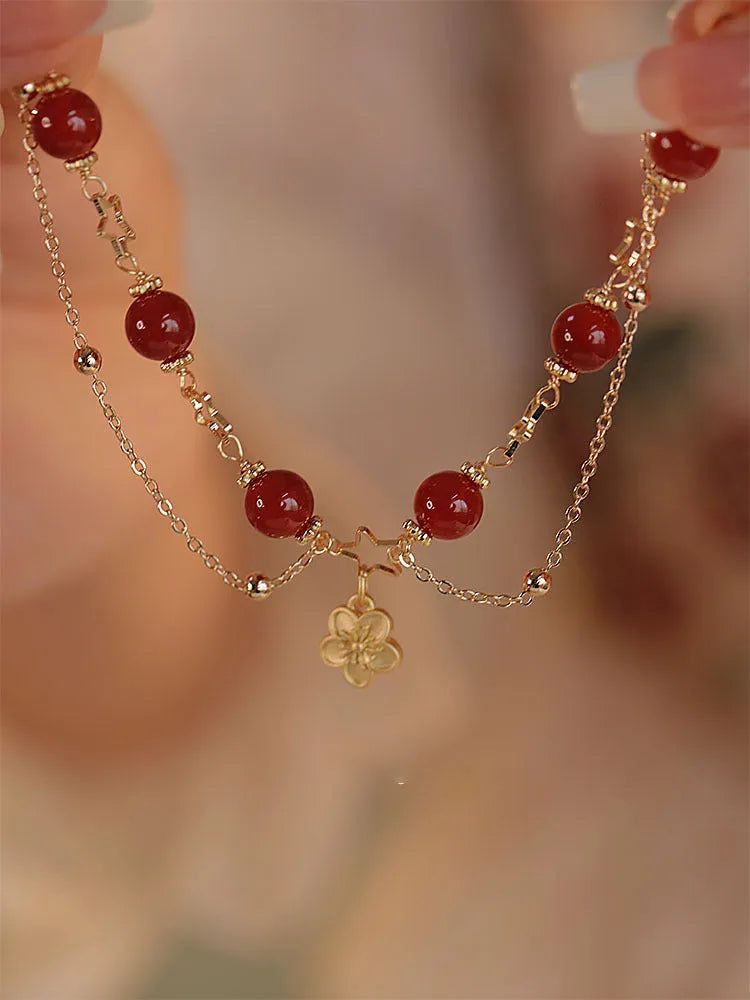 Close-up of natural red agate double layer bracelet with manual floral and peach blossom details for women.