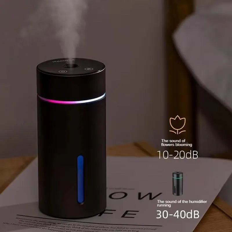 Black portable aluminium car air humidifier and essential oil diffuser with night light on a desk.