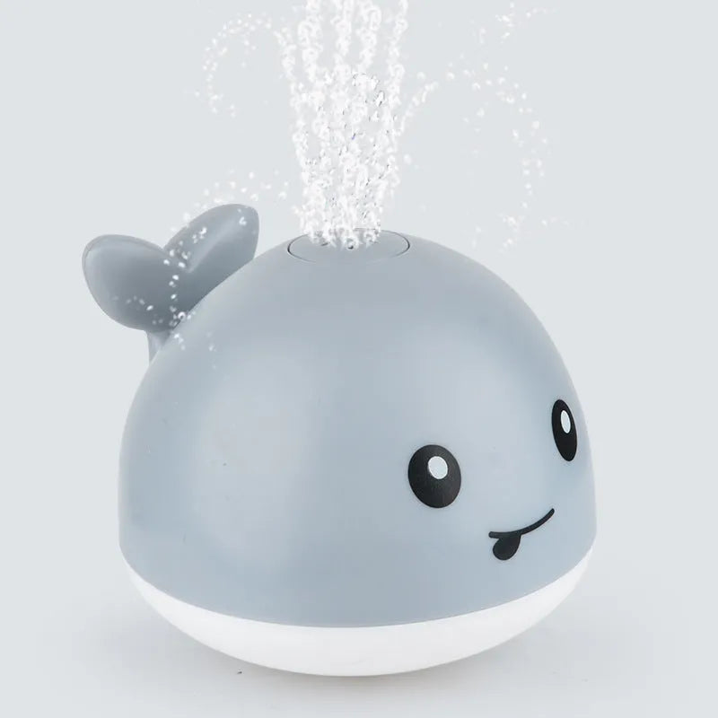 Automatic spray whale bath toy with LED lights floating in water